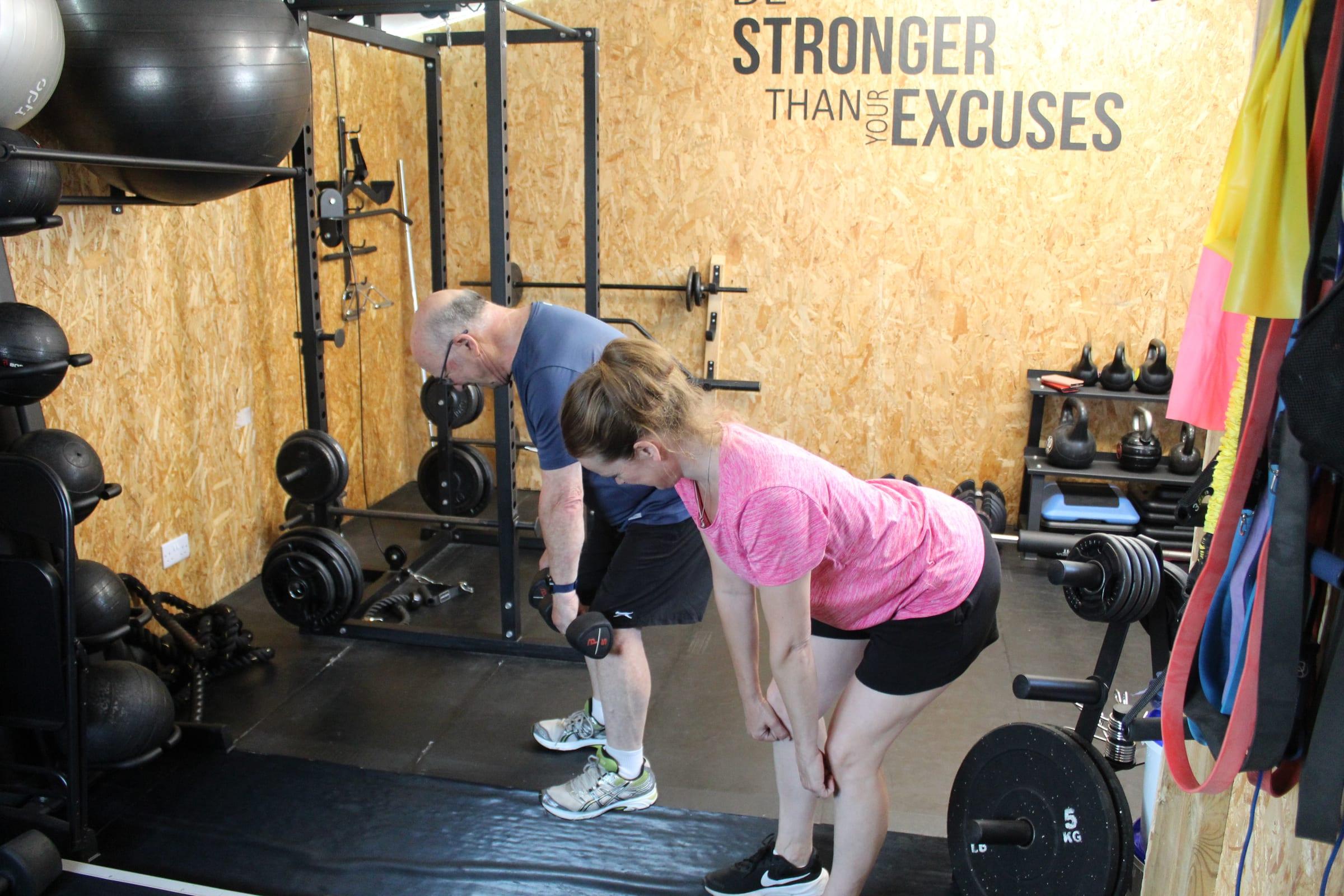 Two clients working through a dumbbell deadlift together in the private Worthing studio