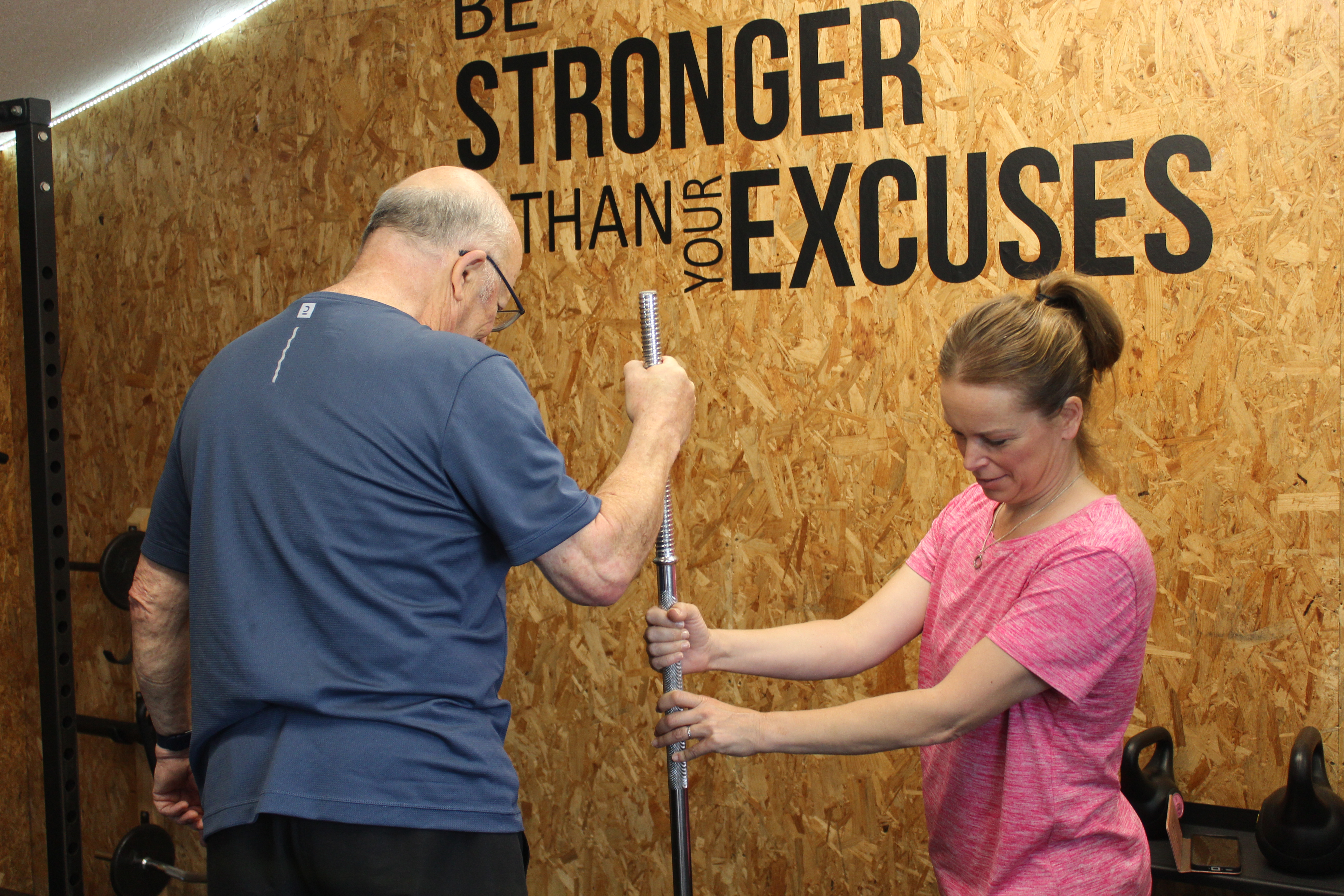 Esther steadying a barbell for a client in the studio