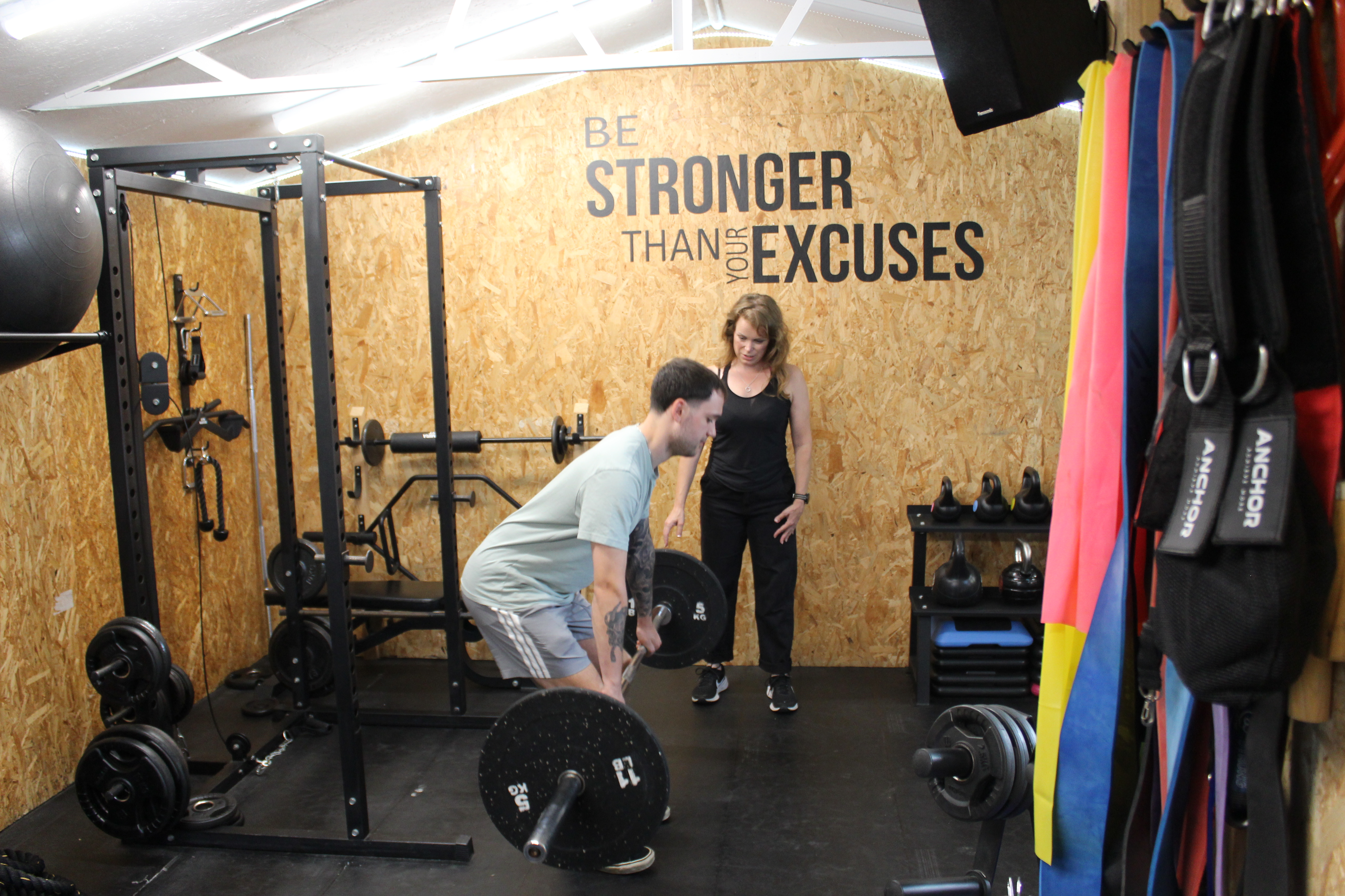 Esther Fair coaching a client through a deadlift in her private studio in Worthing