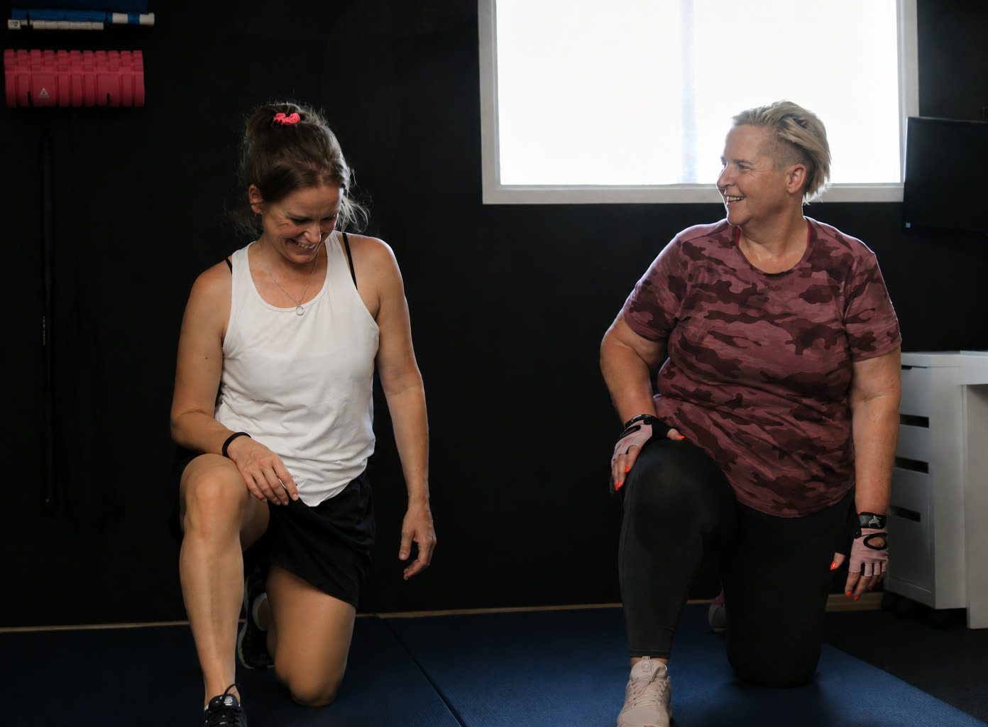 Esther and a client working through a kneeling hip stretch on the mats in the private Worthing studio