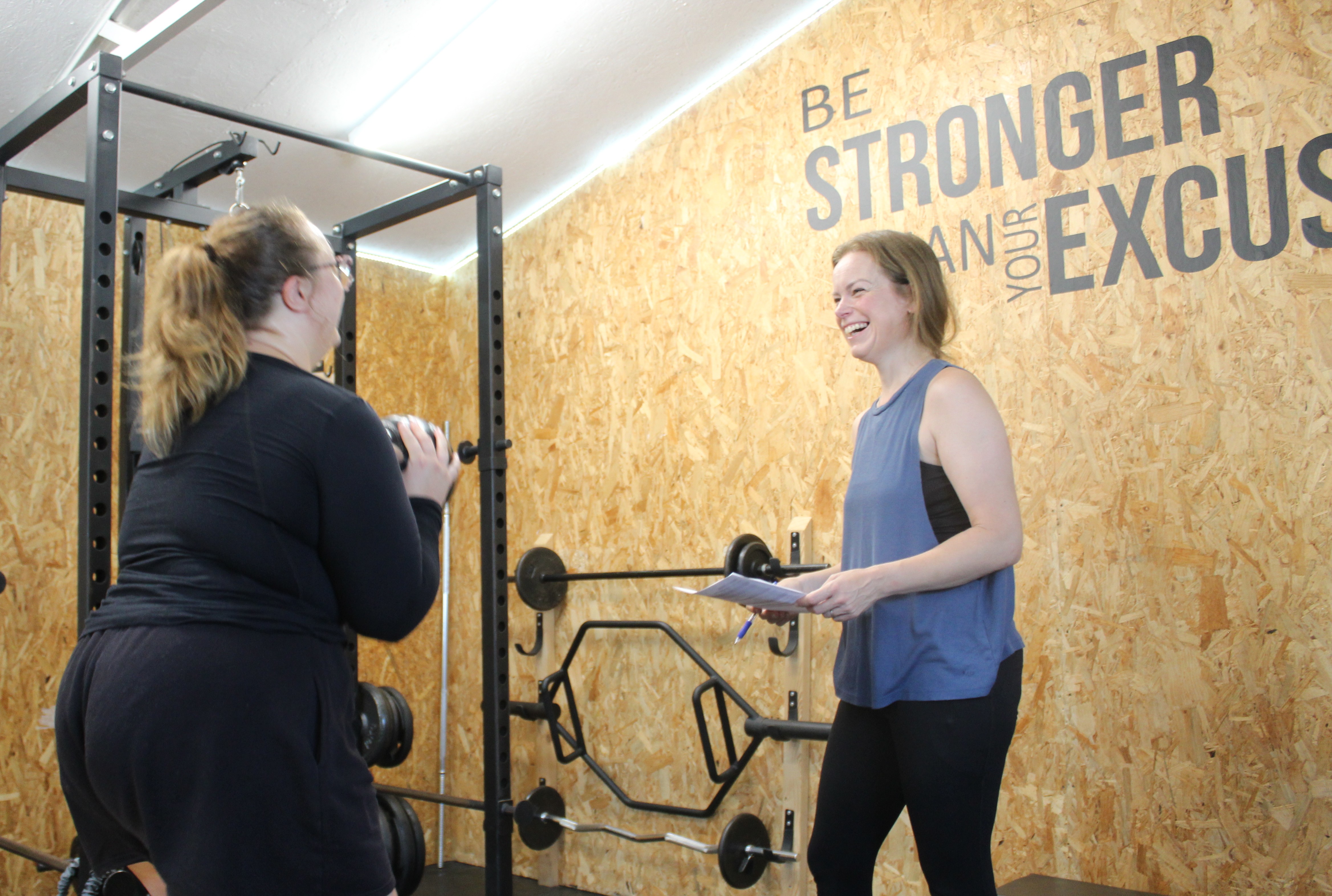 Esther Fair coaching a client through a session, reviewing their programme notes in the private Worthing studio